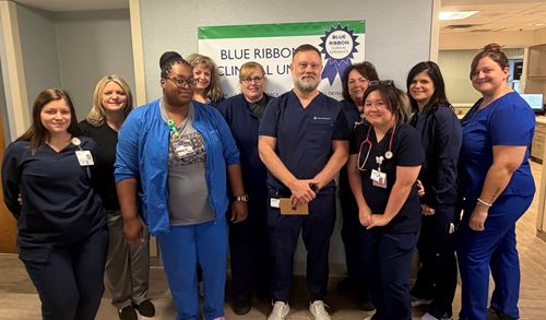 A group of nurses standing for a photo celebrating a fellow nurse